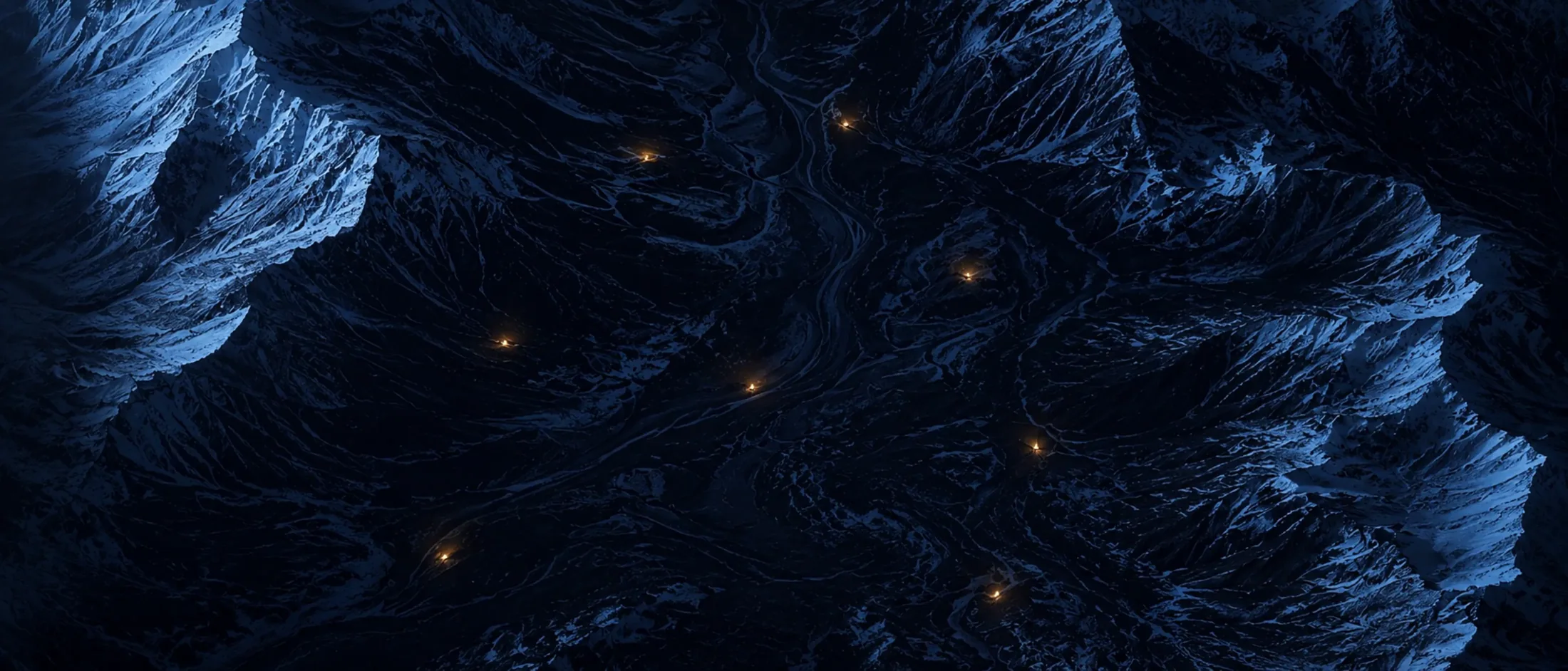 Alpental bei Nacht von oben, einzelne orange Lichter in der Dunkelheit